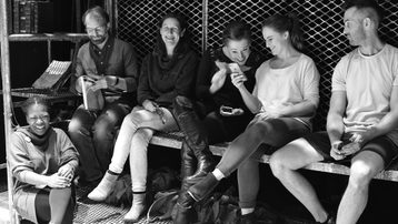 A group of people relaxing offstage during rehearsals