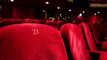 Red theatre seats with gold embroidered numbers