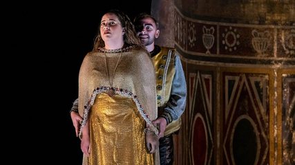 A woman in a gold dress stands menaced by a leering man