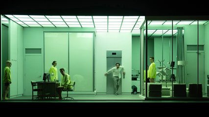 a man stands in front of an elevator in an uncanny version of an office