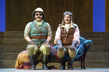 Ferranda and Guglielmo are in disguise and sitting on a chaise longue