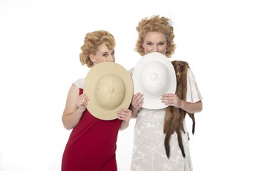 Season artwork for ETO's Così fan tutte, two sisters dressed in 1920's clothes, they are holding two hat's that explorers might wear, they are using them to hide their faces and are playfully peeking over the tops of the hats.