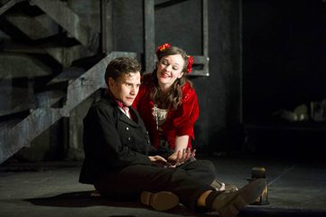 Masetto is sitting on the floor and Zerlina is beside him. Zerlina is comforting Masetto