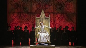 Elizabeth I sitting on throne surrounded by chorus
