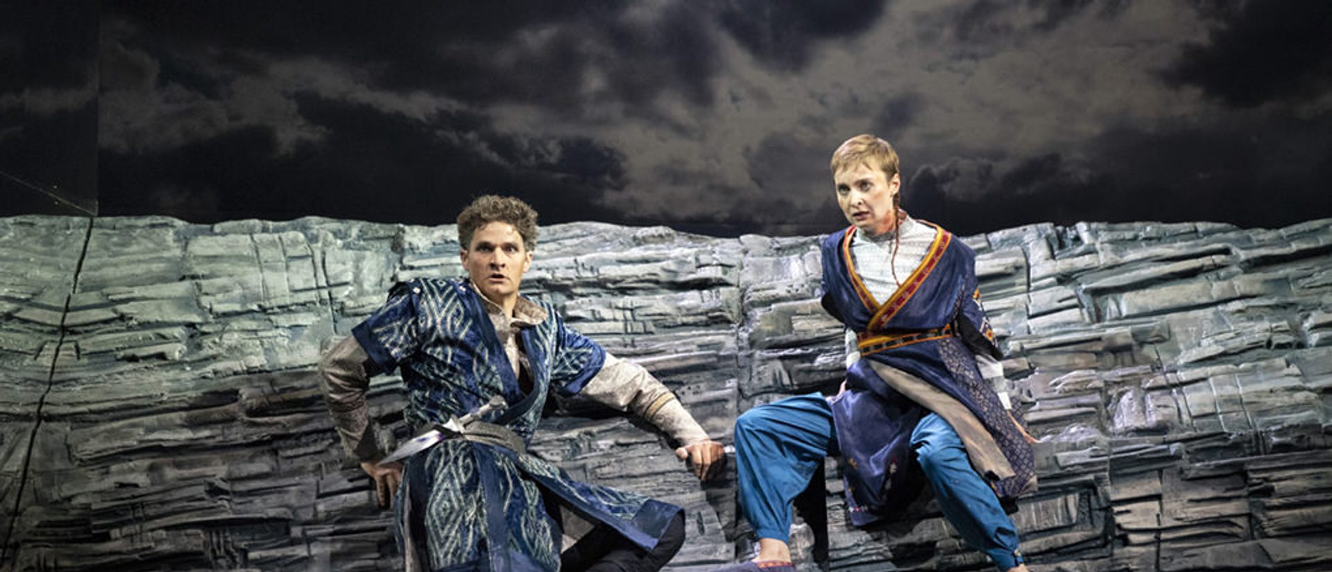 Two opera singers on a rocky, grey lancscape in ETO's 2018 Radamisto